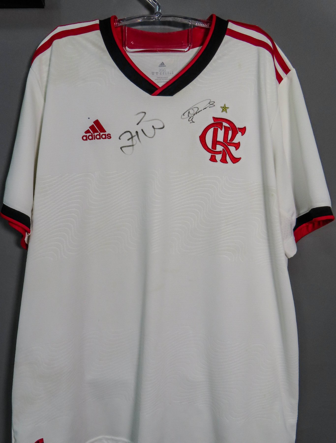 Camisa oficial de jogo/torcedor modelo reserva (away) do Flamengo referente à temporada 2020, fabricada pela Adidas. A peça possui o escudo do clube (CRF), logo da fornecedora - autógrafo manual - Zico e Nunes.